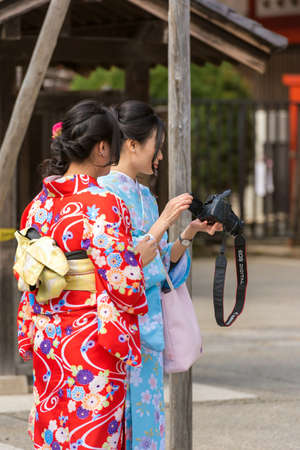 TOKYO, JAPAN - OCTOBER 31, 2017: Two girls in a kimono on a city street. Vertical