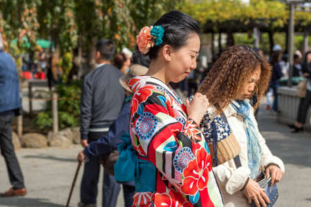 TOKYO, JAPAN - OCTOBER 31, 2017: Girl in a red kimono on a city street. Close-upのeditorial素材