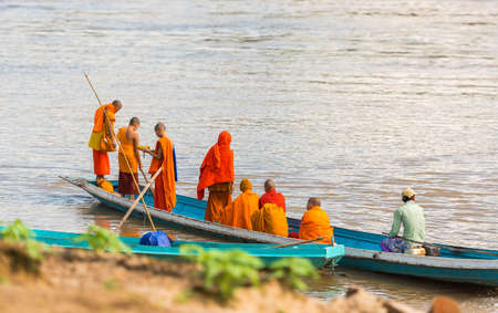 LUANG PRABANG, LAOS - JANUARY 11, 2017: Monks in a boat on the river Nam Khan river. Copy space for textのeditorial素材