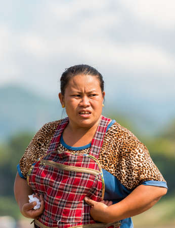 LUANG PRABANG, LAOS - JANUARY 11, 2017: Portrait of a laotian woman in the garden. Vertical. Copy space for textのeditorial素材