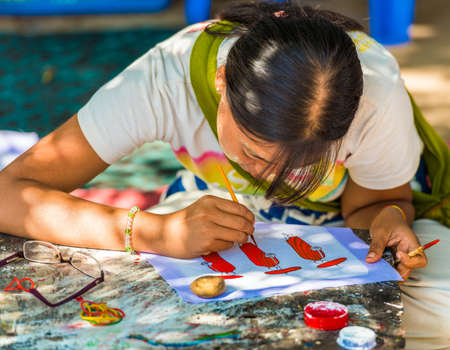 BAGAN, MYANMAR - DECEMBER 1, 2016: Girl is painting on a city street. Close-upのeditorial素材