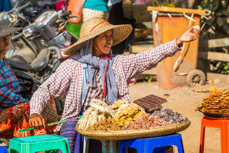 BAGAN, MYANMAR - DECEMBER 1, 2016: The seller of seafood, sweets in the local market. Close-upのeditorial素材