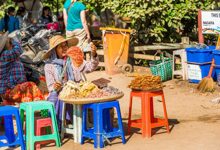 BAGAN, MYANMAR - DECEMBER 1, 2016: The seller of seafood, sweets in the local market. Copy space for textのeditorial素材