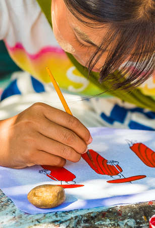 BAGAN, MYANMAR - DECEMBER 1, 2016: Girl is painting on a city street. Close-upのeditorial素材
