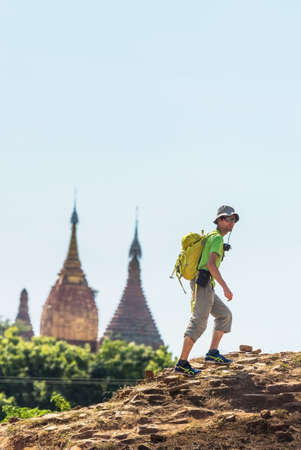 BAGAN, MYANMAR - DECEMBER 1, 2016: A man with a backpack is climbing a mountain. Copy space for text. Verticalのeditorial素材