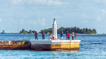 MALE, MALDIVES - NOVEMBER, 27, 2016: Fishermen on the dock fishing. Copy space for text.のeditorial素材