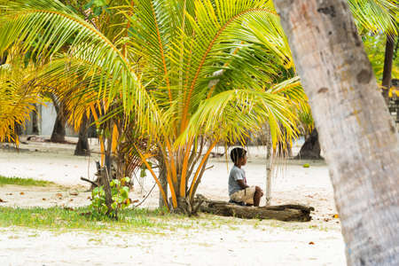 MALE, MALDIVES - NOVEMBER, 27, 2016: Little boy under the palm tree. Copy space for textのeditorial素材