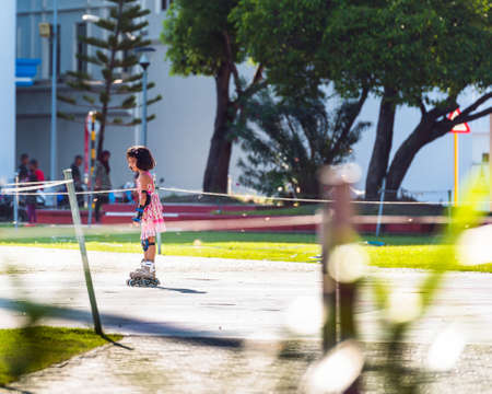 MALE, MALDIVES - NOVEMBER, 27, 2016: Little girl in a pink dress on roller skates. Copy space for textのeditorial素材