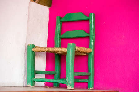 Green wooden chair on a pink wall background, Santo Domingo, Dominican Republic. Copy space for textの写真素材