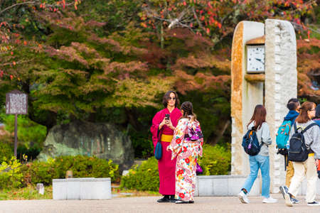 KYOTO, JAPAN - NOVEMBER 7, 2017: A couple in a kimono walks in the city park. Copy space for textのeditorial素材