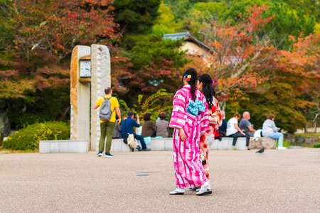 KYOTO, JAPAN - NOVEMBER 7, 2017: Two girls in a kimono on a city street. Copy space for textのeditorial素材