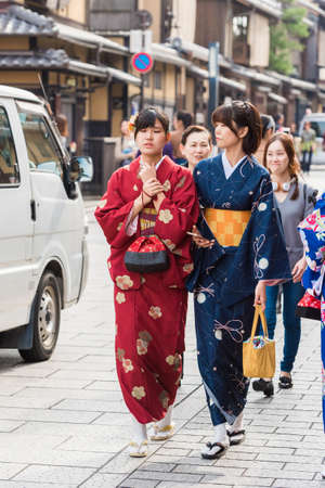 KYOTO, JAPAN - NOVEMBER 7, 2017: A group of girls in a kimono sit on a bench. Close-upのeditorial素材