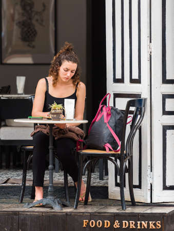 LUANG PRABANG, LAOS - JANUARY 11, 2017: Girl in outdoor cafe. Copy space for textのeditorial素材