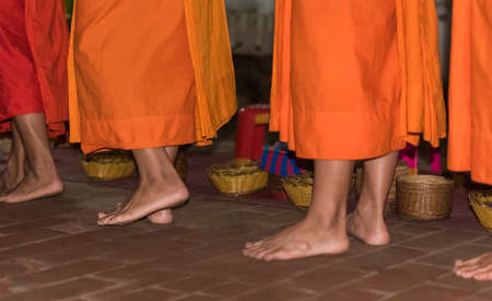 The feet of monks close-up. Feeding the monks. The ritual is called Tak Bat, Luang Prabang, Laosの写真素材