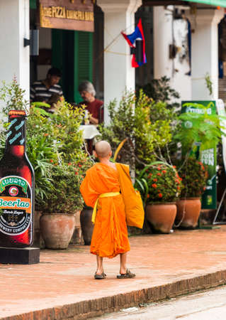 LUANG PRABANG, LAOS - JANUARY 11, 2017: Little monk on a city street. Copy space for text. Verticalのeditorial素材