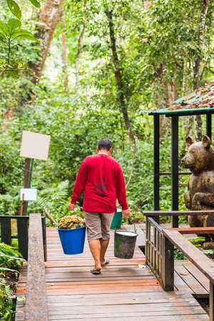 LUANG PRABANG, LAOS - JANUARY 11, 2017: The man at the zoo with buckets. Vertical. Copy space for...
