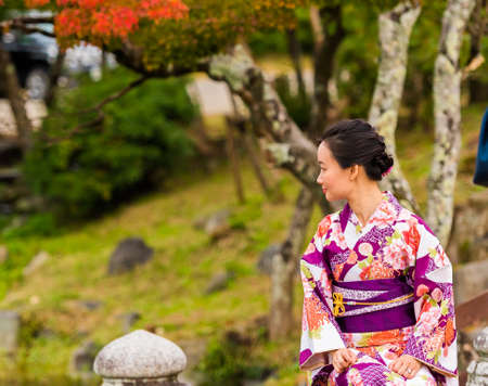 KYOTO, JAPAN - NOVEMBER 7, 2017: A girl in a kimono against the background of a city park. Copy space for textのeditorial素材
