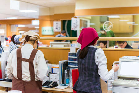 KYOTO, JAPAN - NOVEMBER 7, 2017: Workers at the ticket office at a local cafe. Copy space for text