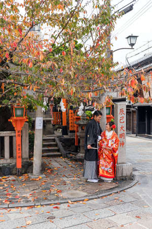 KYOTO, JAPAN - NOVEMBER 7, 2017: A couple in a kimono on a city street. Copy space for text. Verticalのeditorial素材