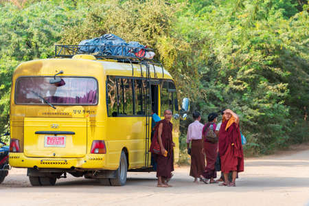 BAGAN, MYANMAR - DECEMBER 1, 2016: Yellow bus with monks on the roadside. Copy space for textのeditorial素材