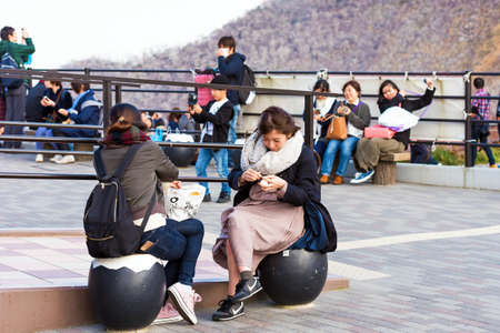 HAKONE, JAPAN - NOVEMBER 5, 2017: People in clean chicken black eggs. Copy space for text