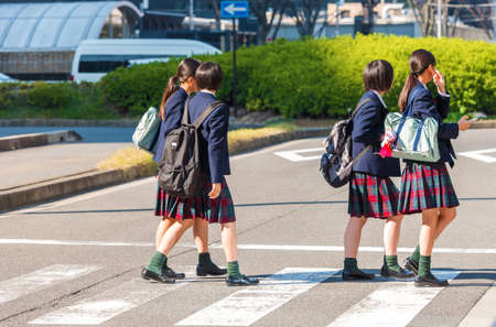 Japanese schoolgirl on a city street, Kyoto, Japan.のeditorial素材