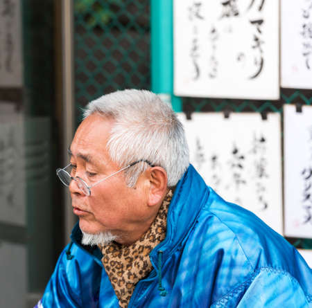 TOKYO, JAPAN - NOVEMBER 7, 2017: The gray-haired man in glasses on a city street. Close-upのeditorial素材