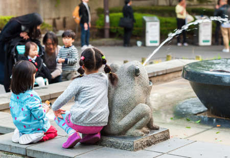 TOKYO, JAPAN - NOVEMBER 7, 2017: The girls are sitting near the fountainのeditorial素材