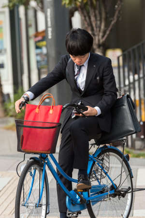 TOKYO, JAPAN - OCTOBER 31, 2017: Boy on a bike on a city street. Verticalのeditorial素材
