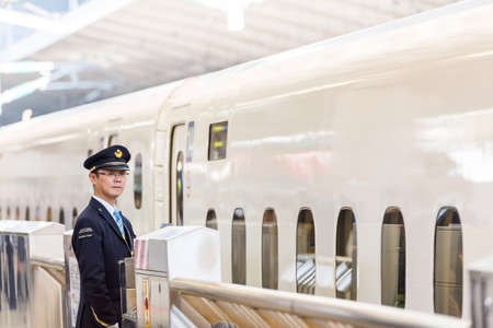 TOKYO, JAPAN - NOVEMBER 7, 2017: A train station worker stands near a train. Copy space for textのeditorial素材