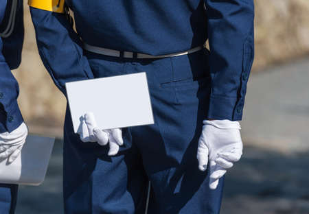 A man in white gloves holds a white sheet behind his back, Kyoto, Japan. Copy space for text. Frame for textの写真素材