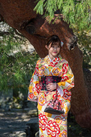 KYOTO, JAPAN - NOVEMBER 7, 2017: Girl in a kimono in a city park. Verticalのeditorial素材