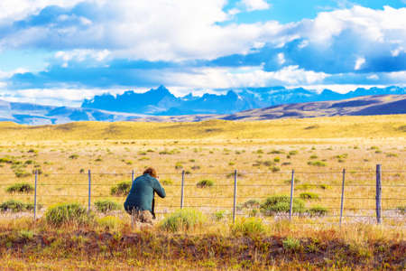Photographer takes pictures of a mountain landscape, Patagonia, Chile. Back viewの写真素材