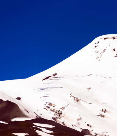 The top of the volcano Vicente Perez Rosales, Chile. Isolated on blue backgroundの写真素材