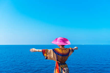 Girl in a pink hat on the background of the sea, Maldives. Copy space for text. Back viewの写真素材