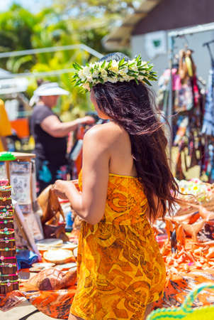 Girl with white wreath of flowers, Rarotonga, Aitutaki, Cook Islands. With selective focus. Back view. Verticalの写真素材