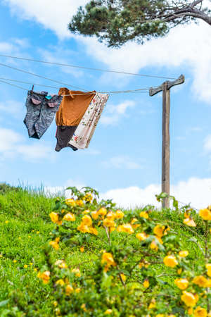 MATAMATA, NEW ZEALAND - OCTOBER 10, 2018: Things are drying on a rope, Hobbiton Movie Set. Vertical. With selective focusのeditorial素材