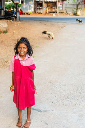 PUTTAPARTHI, INDIA - NOVEMBER 29, 2018: Indian girl outdoors barefoot. Verticalのeditorial素材