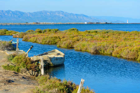 Boat on a Canal in Ebro Delta estuary and wetlands, Tarragona, Catalunya, Spain.の写真素材