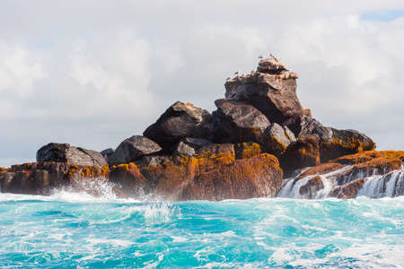 Rock in the ocean on a background of the cloudy sky, Galapagos Island, Isla Isabela