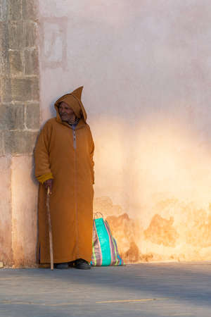 Essaouira, Morocco - November 17, 2019: A man in typical moroccan clothes on a city street. Verticalのeditorial素材