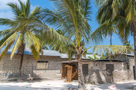 Zanzibar, Tanzania - February 8, 2020: Street view with a local house with palm trees in the fishing village of Nungwi. Zanzibarのeditorial素材