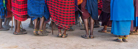 NGORONGORO, TANZANIA - February 15, 2020: Group of Massai People, Panorama shot of the Feet, participating a Traditional Dance with high Jumps, selected Focus during Sunset Timeのeditorial素材