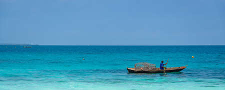 Nungwi Beach, Zanzibar-Tanzania, February 12, 2020: Fischermann on a Boat at Zanzibar Island. Tanzania. Turquoise calm oceanのeditorial素材