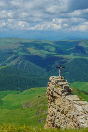 Man on a Rock at the Amazing Bermamyt Plateau. Caucasus Elbrus Region in Russia Summer Landscape with green Meadow, Panorama dramatic Skyの写真素材