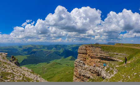 Great nature mountain range. Panorama perspective of caucasian mountain with green fields, blue sky background. Elbrus landscape view - the highest peak of Russia and Europeの写真素材