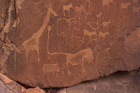 KHORIXAS, NAMIBIA - January 13.2021: Prehistoric Bushman engravings, rock painting at Twyfelfontein, Namibia - Plate with round symbols for waterholes on a rockのeditorial素材