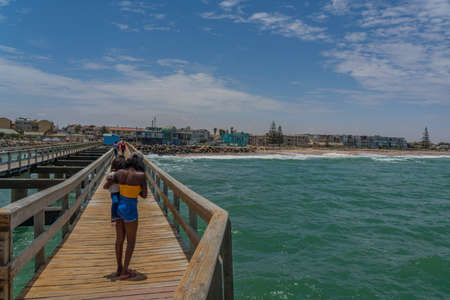 SWAKOPMUND, NAMIBIA - JAN 11, 2020: Promenade in Swakopmund with palm trees and people have rest at the walkingwayのeditorial素材