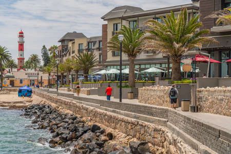 SWAKOPMUND, NAMIBIA - JAN 11, 2020: Promenade in Swakopmund with palm trees and people have rest at the walkingwayのeditorial素材