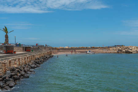 SWAKOPMUND, NAMIBIA - JAN 11, 2020: Promenade in Swakopmund with palm trees and people have rest at the walkingwayのeditorial素材